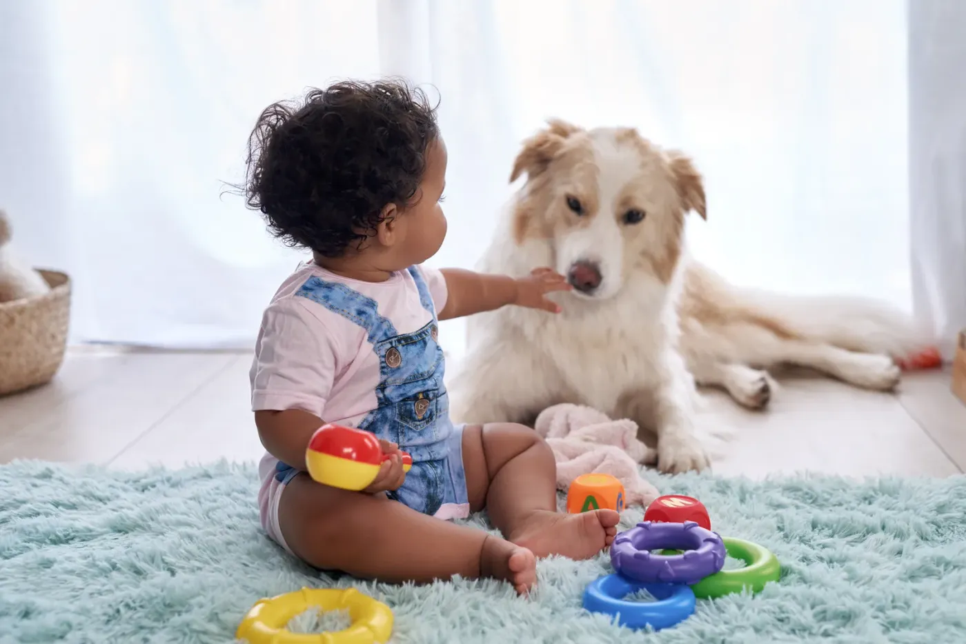 Baby playing on the floor beside a calm dog